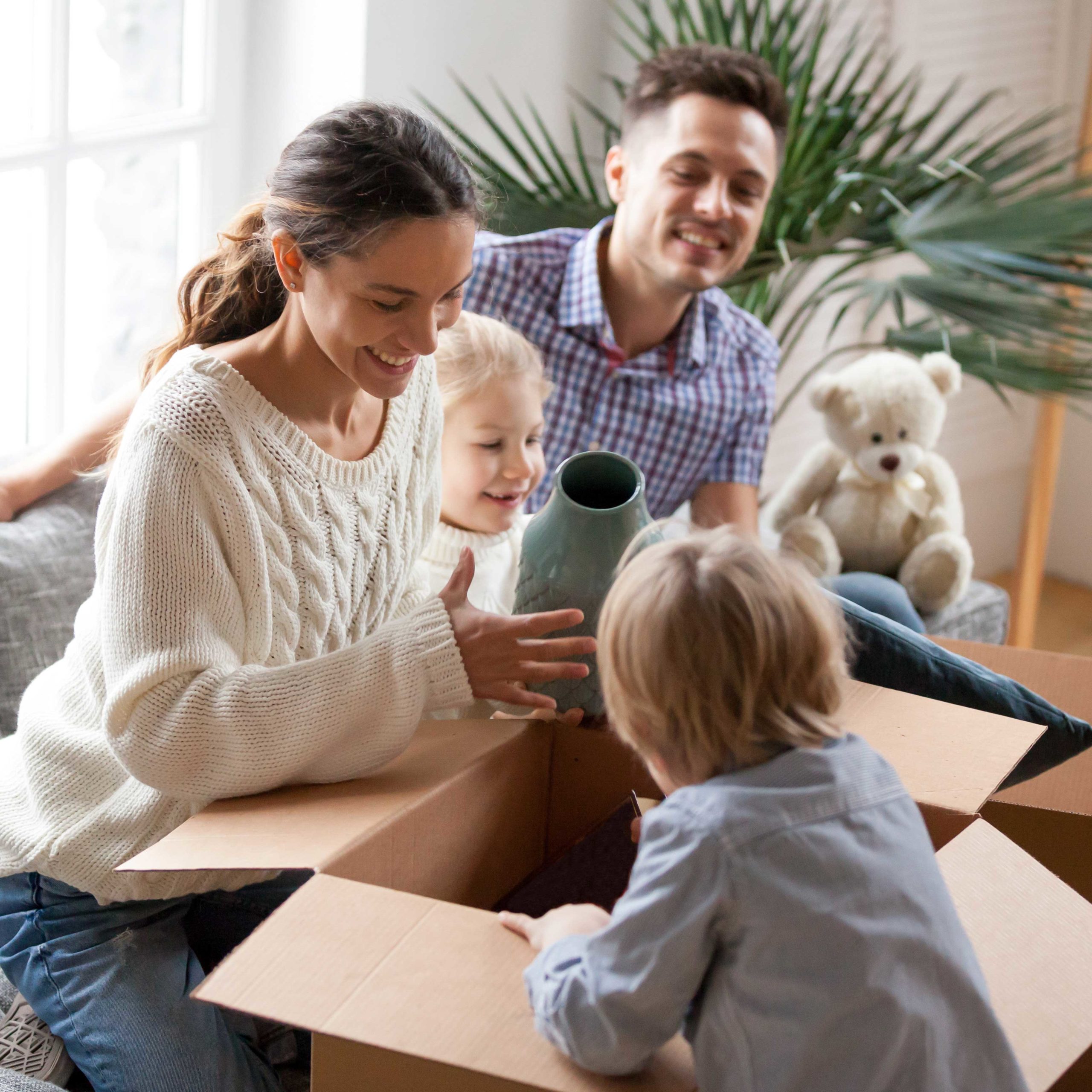 happy-family-with-kids-unpacking-boxes-moving-into-new-homea